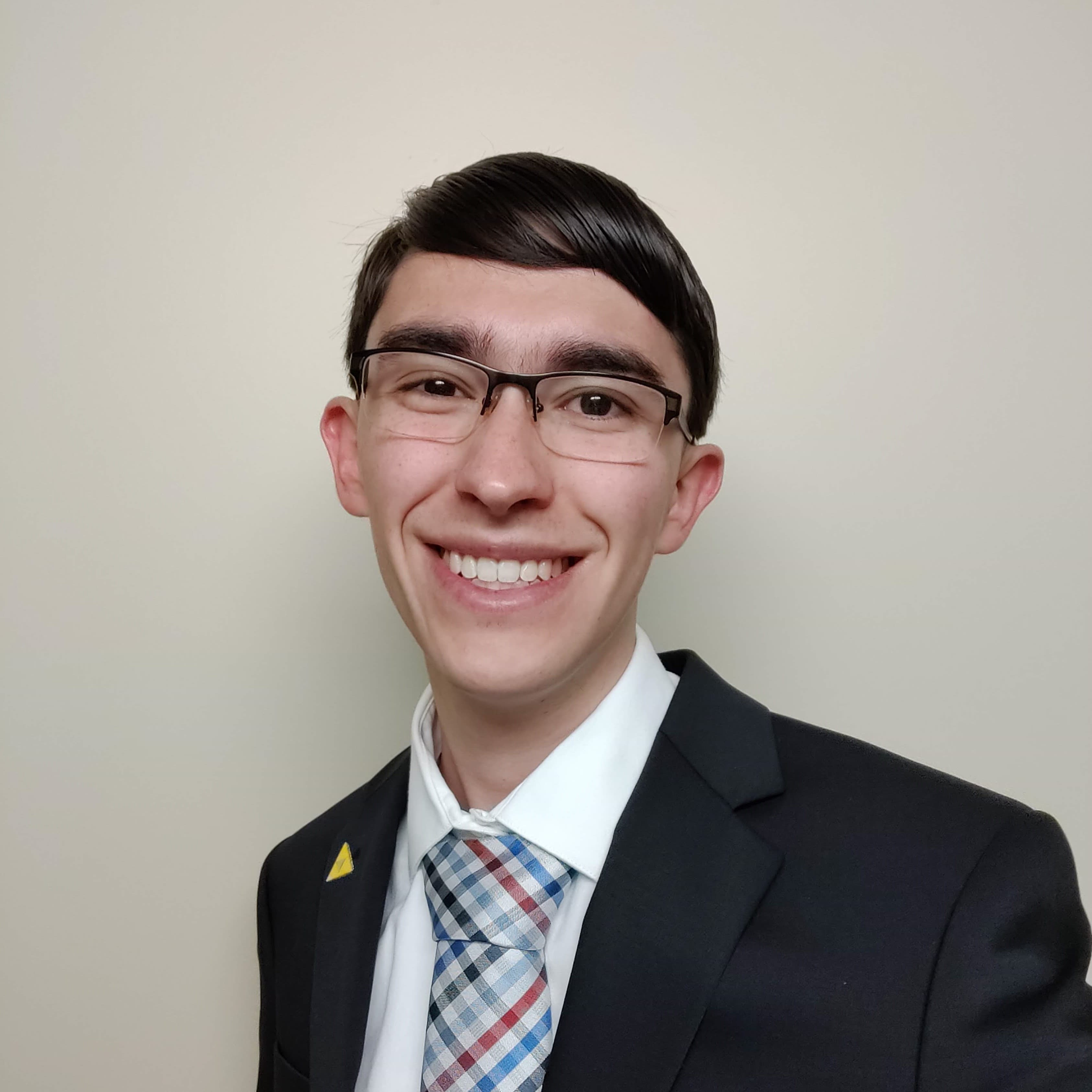 A picture of Daniel in a suit against a plain background.